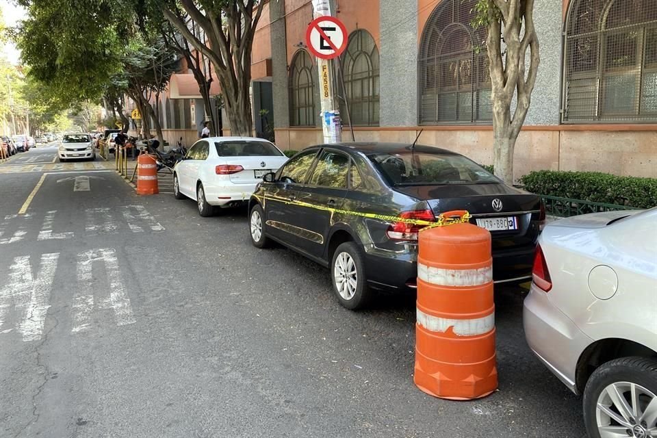 En la Calle Lago de Xochimilco, franeleros apartan lugares para estacionarse, pese a la señalización de prohibición.