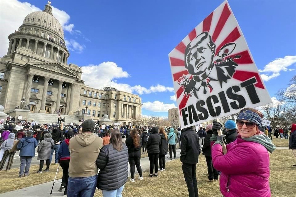 Emily Stoker, de Meridian, Idaho, sostiene un cartel frente al Capitolio estatal de Idaho durante una manifestación contra el Presidente Trump.