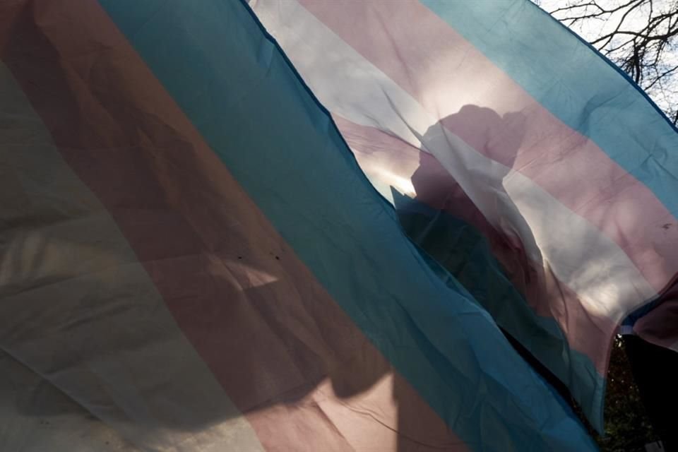 Un manifestante sostiene una bandera trans durante una protesta en Seattle.