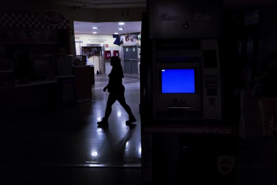 Una mujer camina a través de un centro comercial durante un apagón masivo en Santiago de Chile.