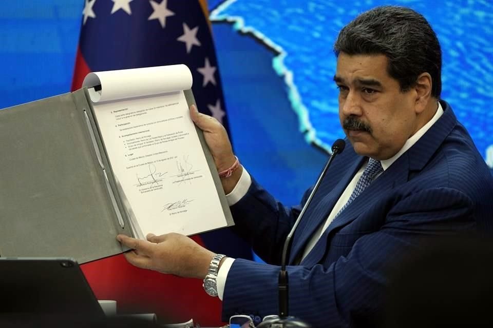 Durante una conferencia de prensa en Caracas, Nicolás Maduro muestra el memorando de entendimiento firmado en la Ciudad de México.