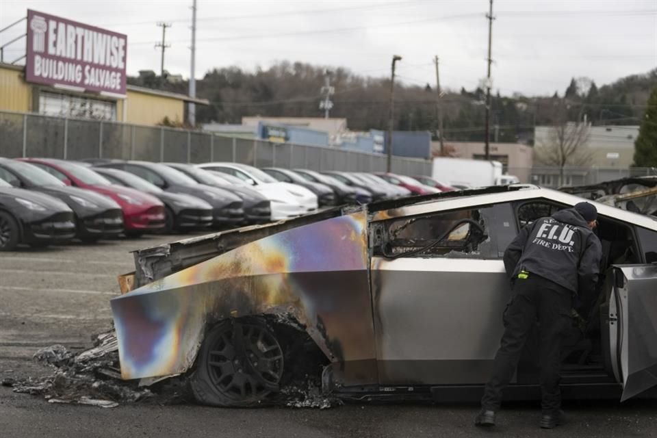 Un integrante del Departamento de Bomberos de Seattle inspecciona un Tesla Cybertruck quemado.