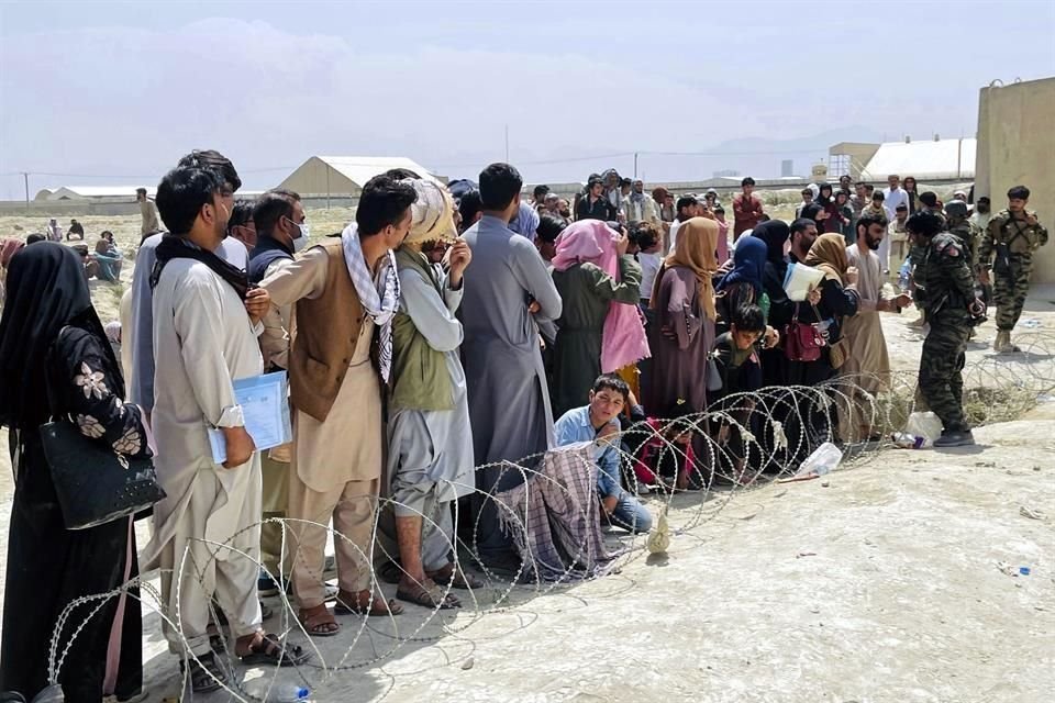 Fuerzas de seguridad afganas tratan de mantener el orden mientras cientos de personas se han congregado en el aeropuerto de Kabul.