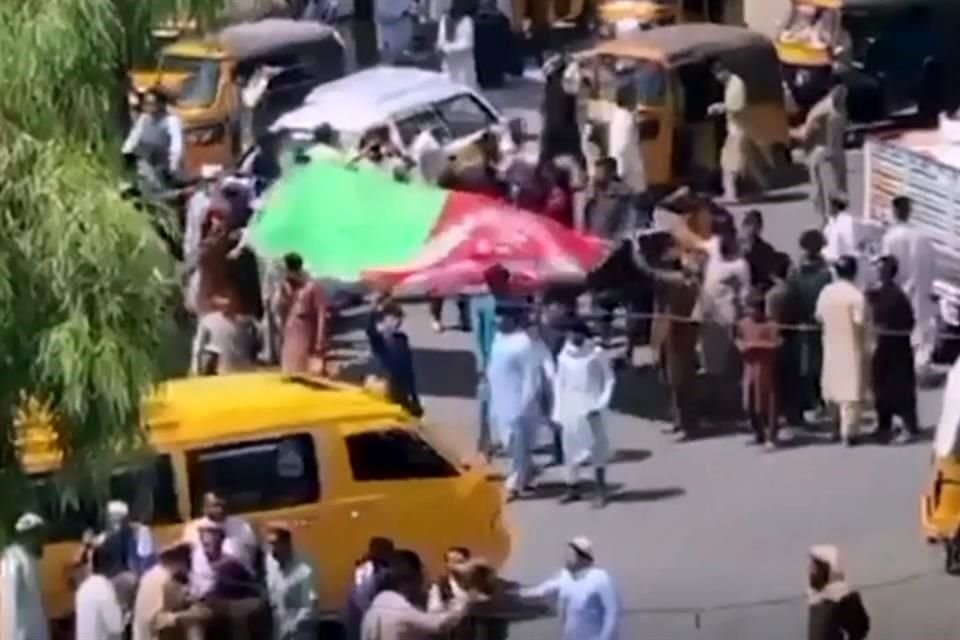 Manifestantes en Jalalabad agitaron una bandera de Afganistán, que ha sido sustituida por la del Talibán (blanca) en edificios públicos.