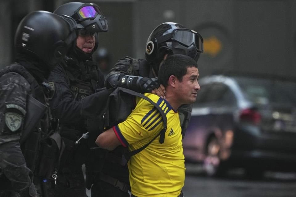 Policías detienen a un aficionado del fútbol local durante una protesta en Buenos Aires.