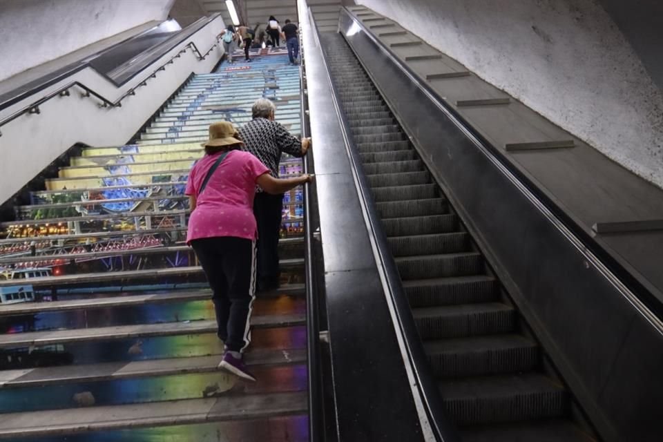 Una mujer de la tercera edad se esfuerza por subir las escaleras en la estación Polanco.