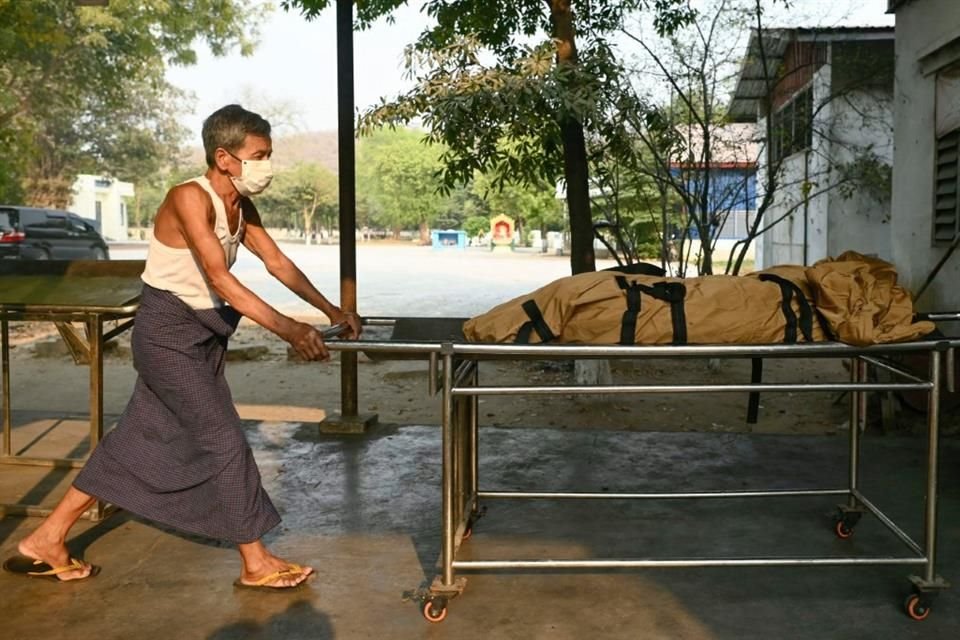 Un trabajador transporta el cuerpo de una víctima para ser enterrado en Mandalay.