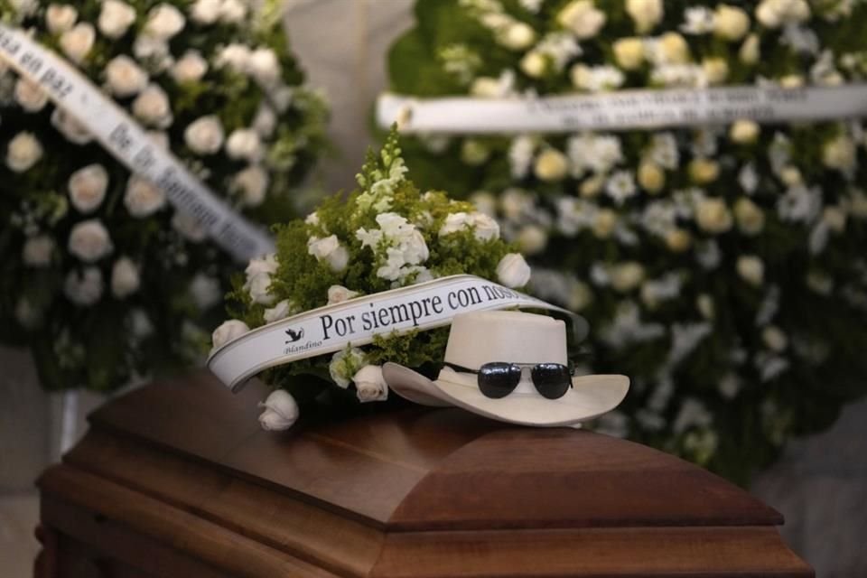 El féretro de Rubby Pérez fue acompañado de varias coronas de flores, su sombrero y sus lentes, símbolos de su estilo.