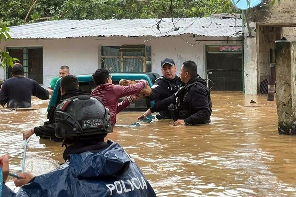 Un perrito es rescatado por Policías Estatales en una calle inundada de Xalapa a causa del paso del huracán 'Grace'.