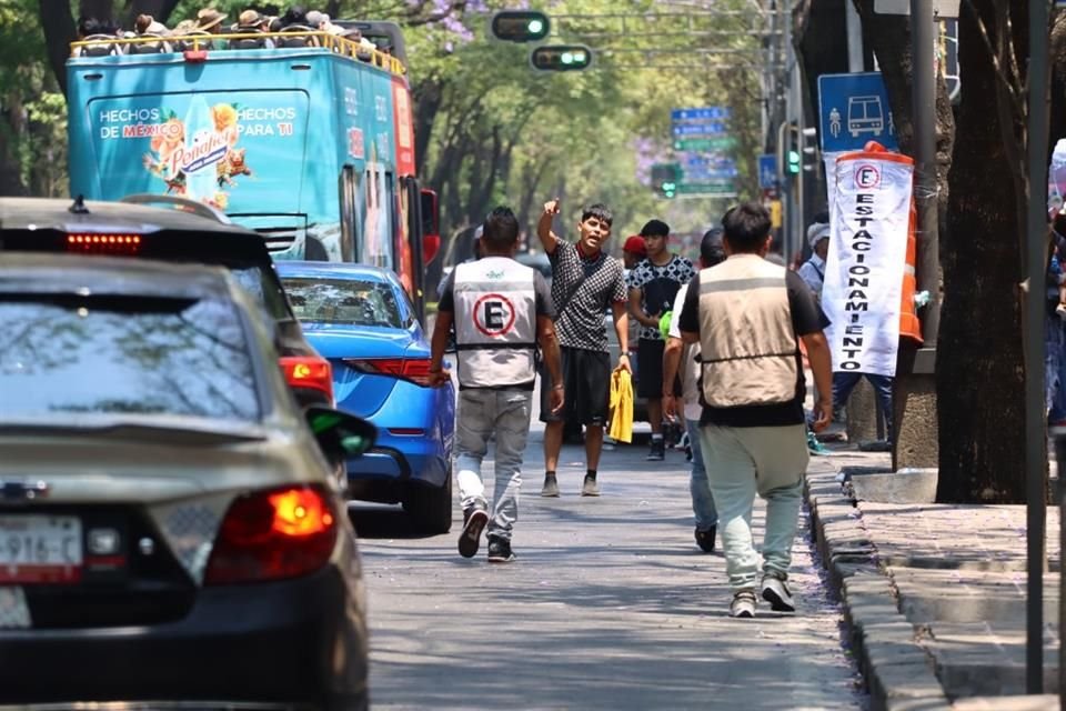 VALETS IRREGULARES. Los franeleros portan letreros y hasta chalecos para anunciar los lugares de estacionamiento que habilitaron.