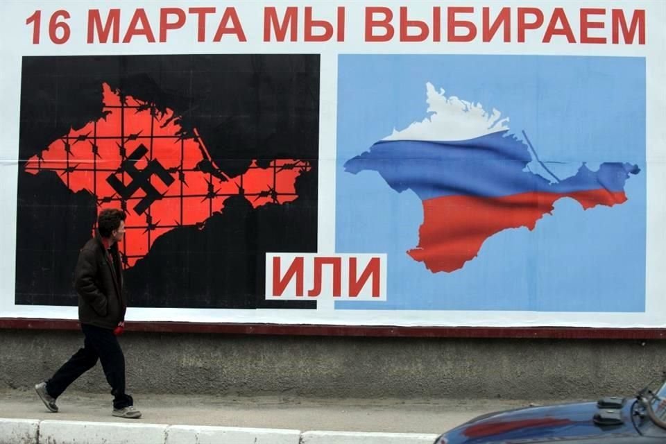 Un hombre pasa junto a un cartel de crimea