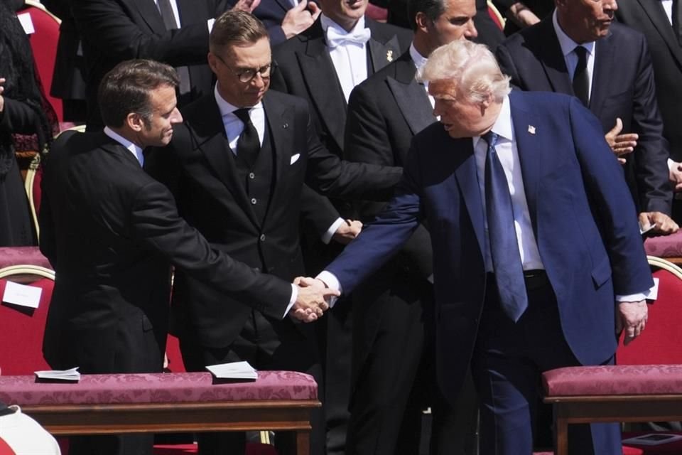 El Presidente Donald Trump estrecha la mano de su homólogo Emmanuel Macron durante misa del Papa.