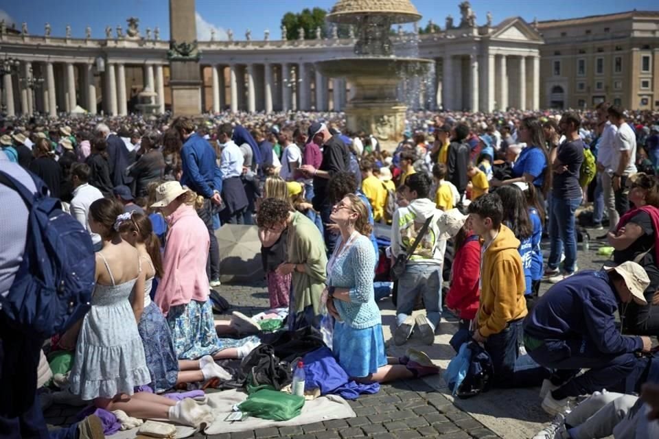 Fieles que acudieron a despedir al Papa Francisco rezan durante la ceremonia.