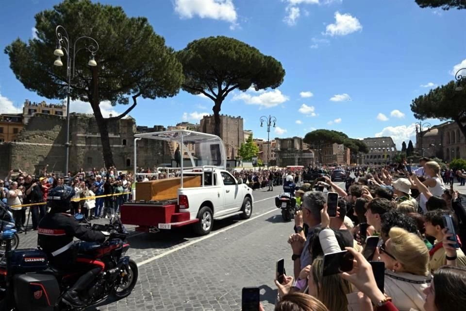La gente se reúne a lo largo de la Via dei Fori Imperiali mientras el ataúd del difunto Papa Francisco es transportado desde la Basílica de San Pedro a la Basílica de Santa María la Mayor.
