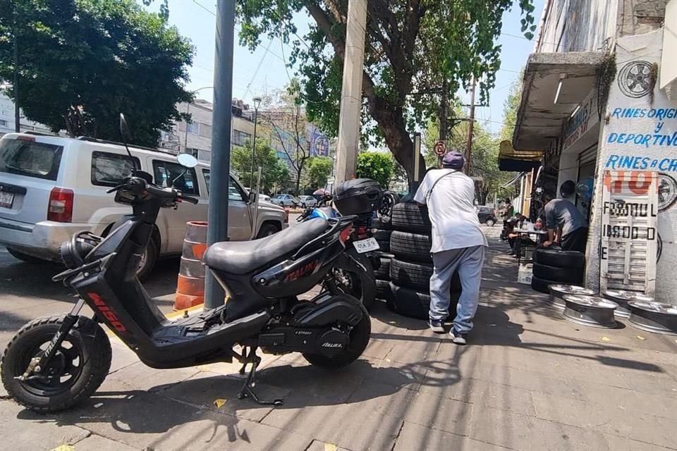 Los establecimientos invaden los pasos peatonales también con refacciones como llantas.