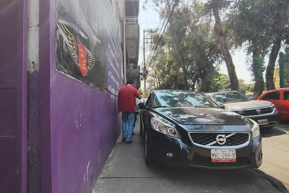 Los peatones y vecinos se ven obligados a esquivar los vehículos estacionados en plena banqueta.