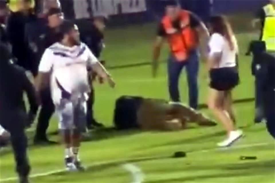 Tras invadir la cancha, aficionados golpearon a gente de seguridad.