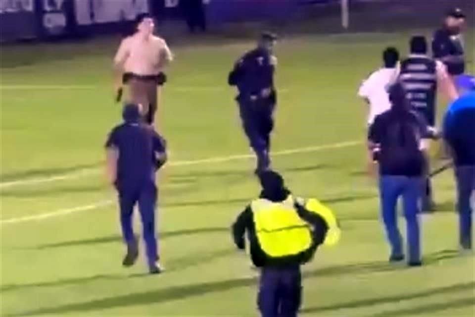La afición intentó alcanzar al elemento de seguridad, quien otra vez con arma en mano, trató de alejarse.