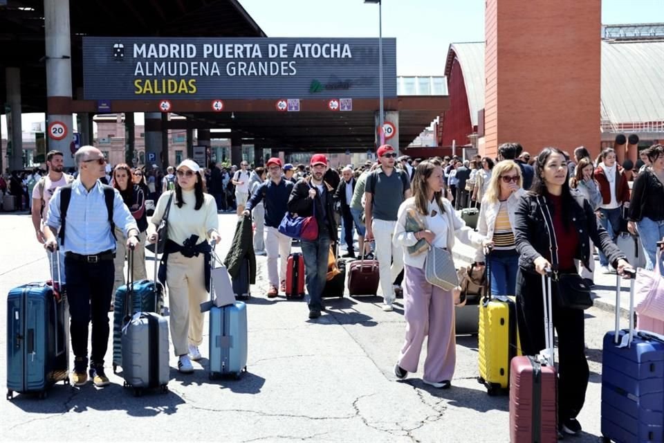 Personas salen de la estación de tren de Atocha, en Madrid, tras su cierre debido al fallo eléctrico nacional.