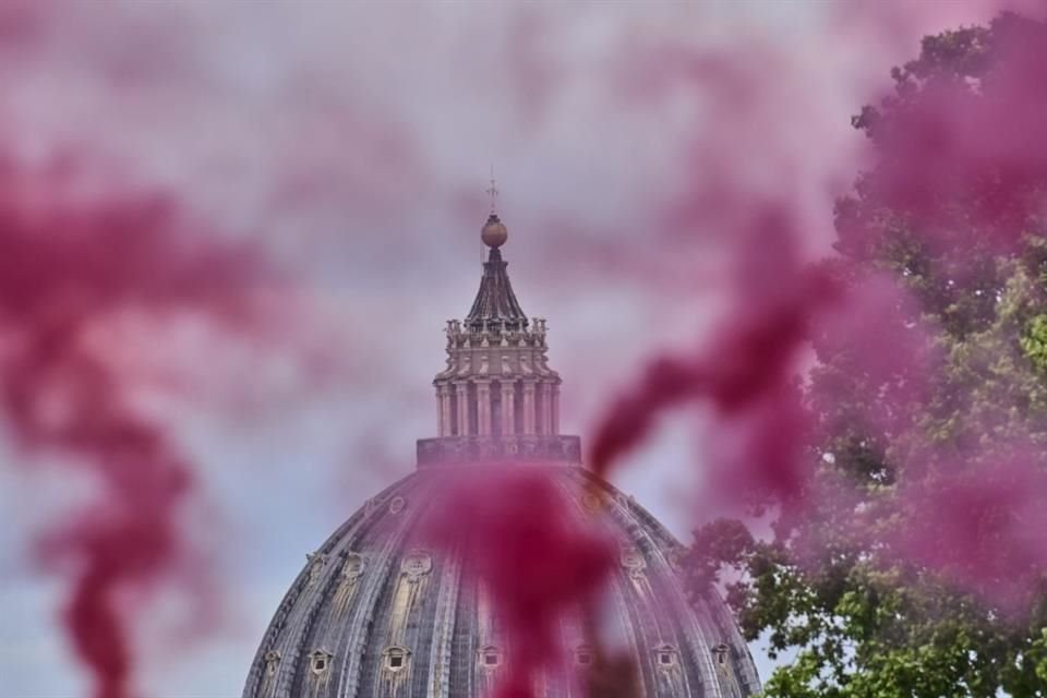 Humo rosa se alza frente a la Basílica de San Pedro, en Roma, el 7 de mayo del 2025.