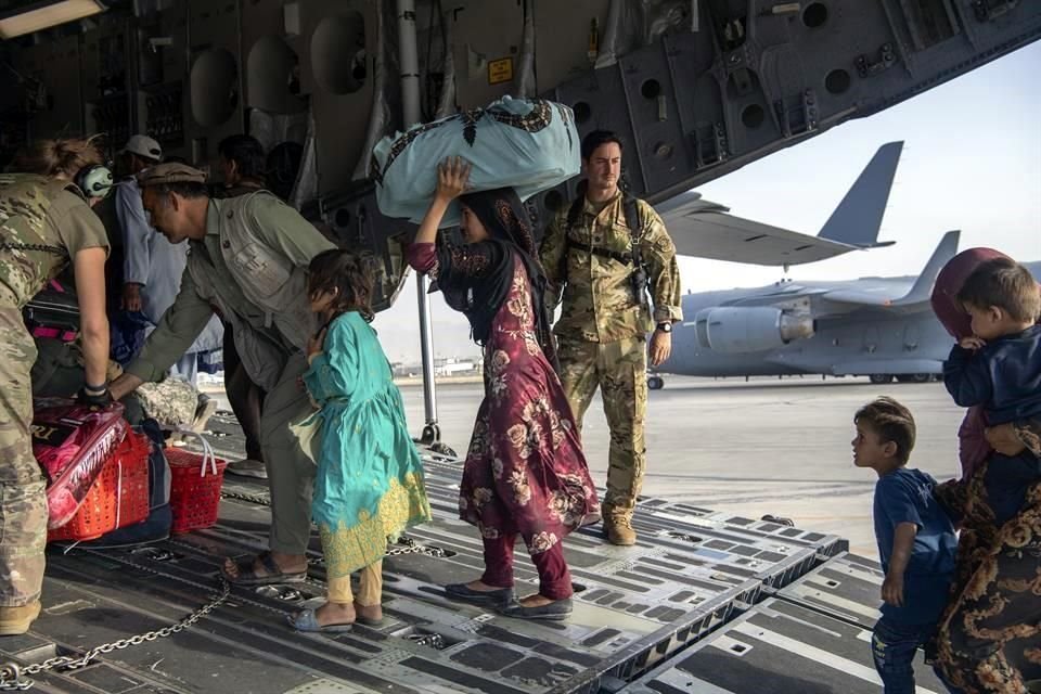 La Fuerza Aérea de EU recibe a personas de Afganistán para sacarlas de Kabul.