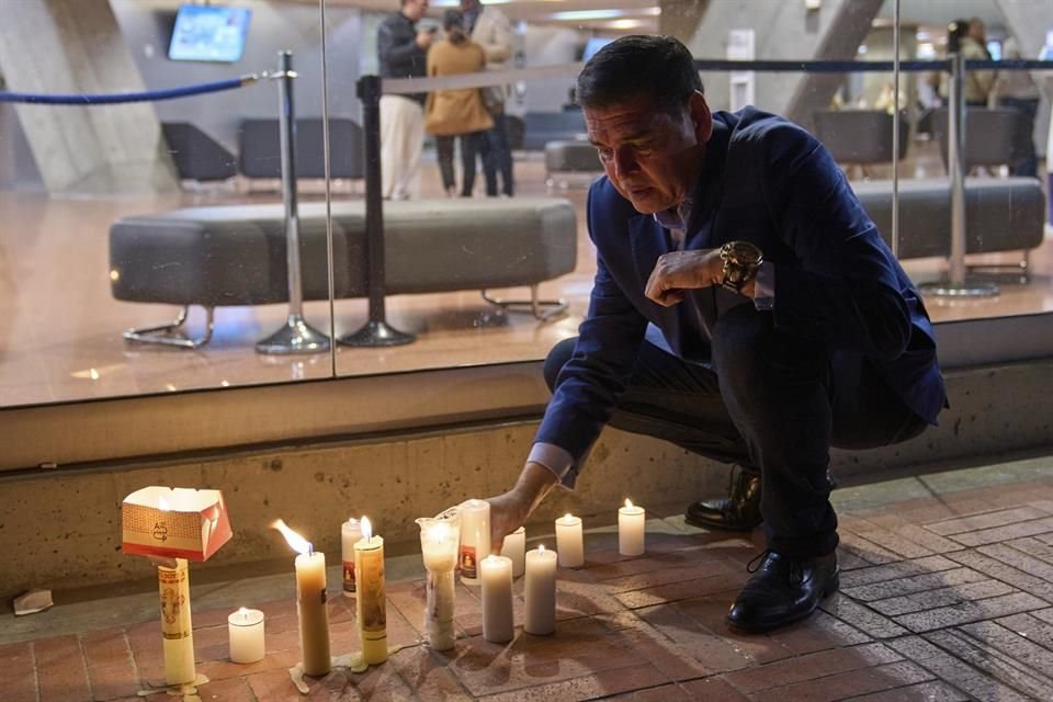 Un hombre enciende velas afuera de la clínica donde el senador colombiano Miguel Uribe Turbay recibe atención médica en Bogotá, Colombia, el 8 de junio de 2025.