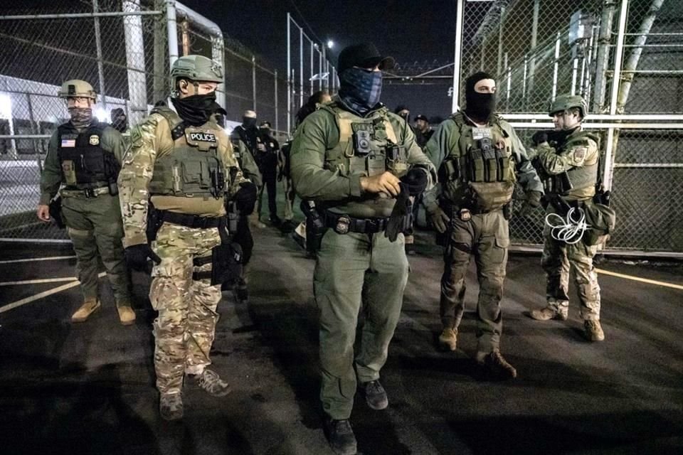 Agentes del Servicio de Inmigración y Control de Aduanas (ICE) vigilan el exterior de Delaney Hall.