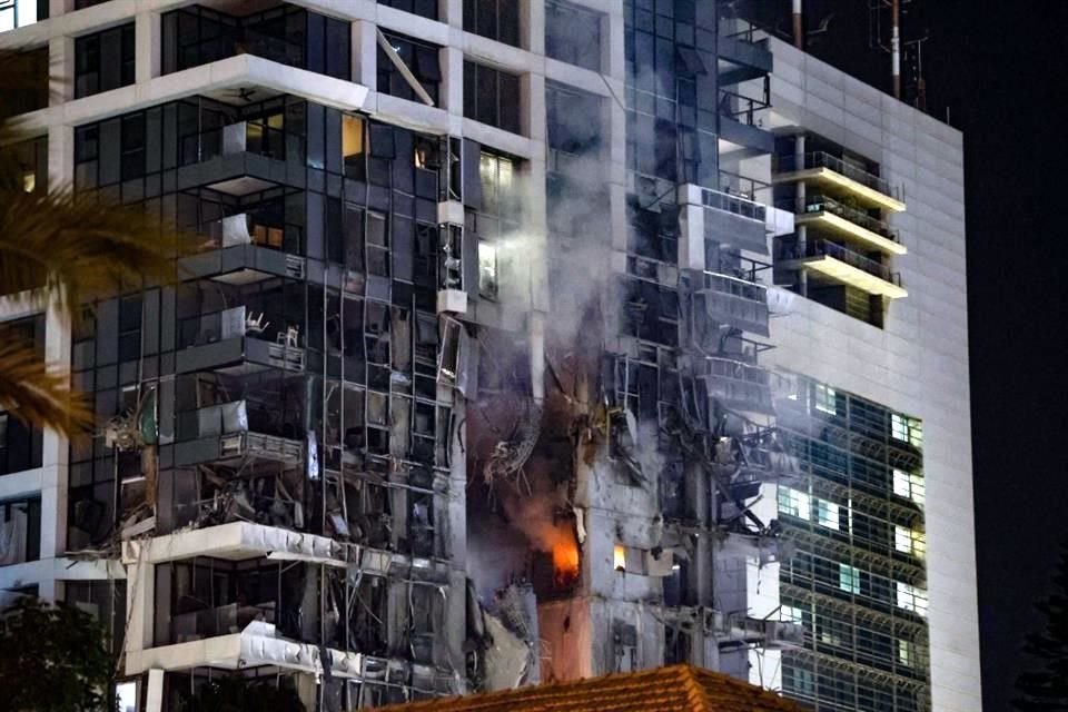 Fuego y humo se elevan desde un edificio, presuntamente alcanzado por un misil lanzado desde Irán, en el centro de Tel Aviv.
