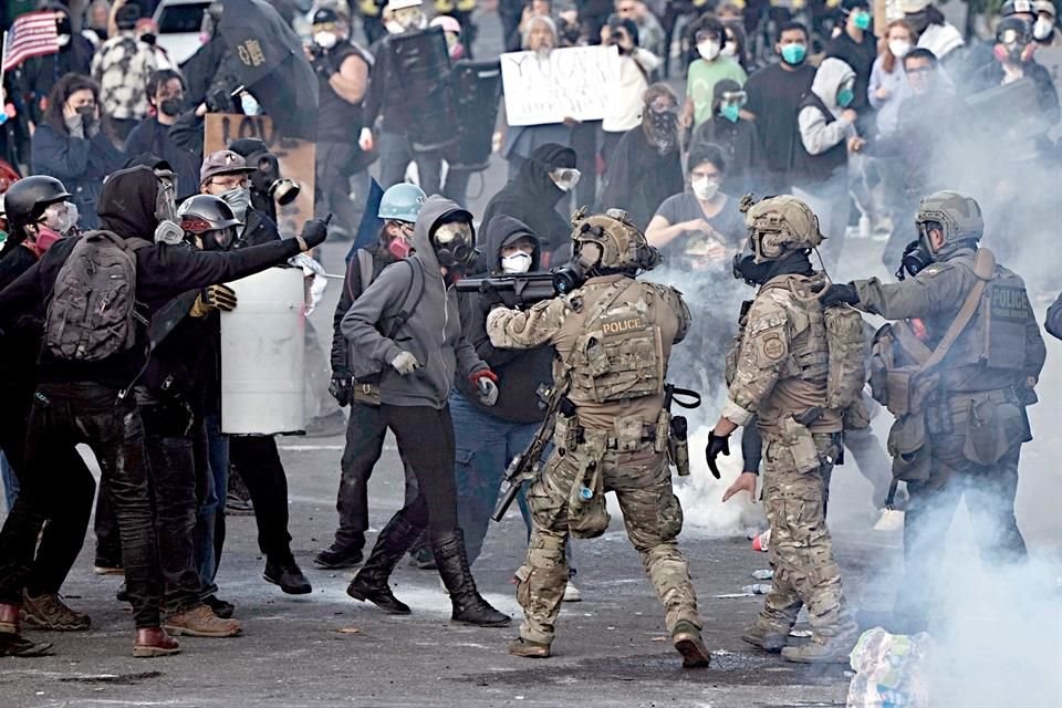 Agentes de Aduanas y Protección Fronteriza enfrentan a manifestantes frente al edificio de Inmigración.