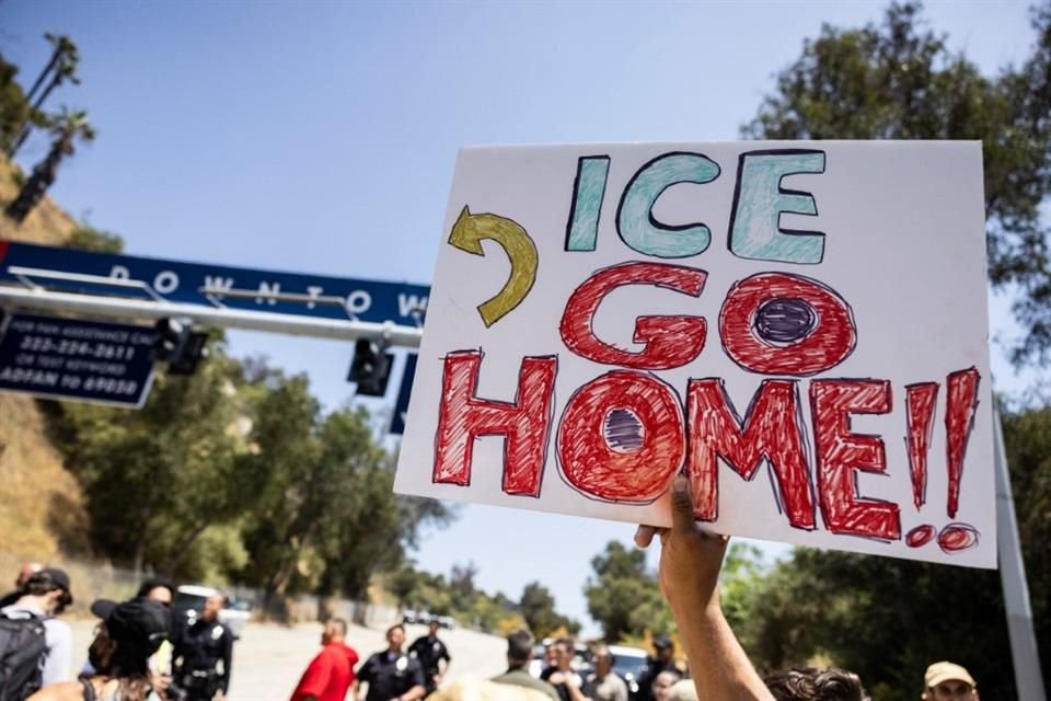 Un manifestante sostiene un cartel con la leyenda 'ICE, váyanse a casa' frente a una de las entradas del estacionamiento del Dodgers Stadium, donde se les negó la entrada a agentes federales.
