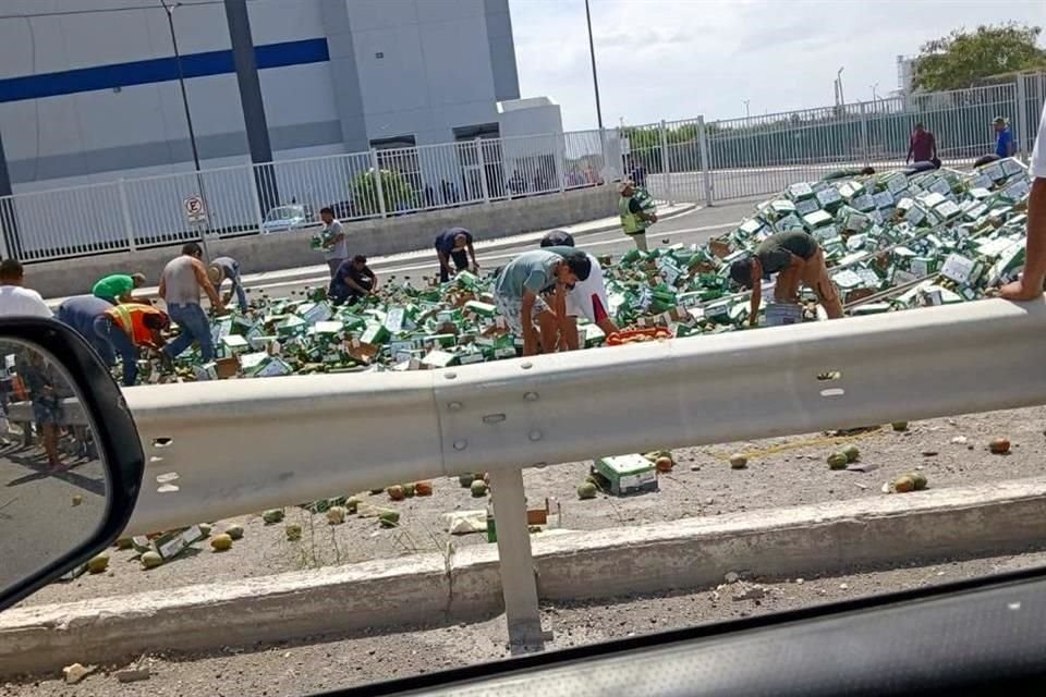 Tras la volcadura de un camión que transportaba mangos sobre el Bulevar Internacional de Reynosa, varias personas arribaron al lugar para llevarse varias cajas con la fruta.