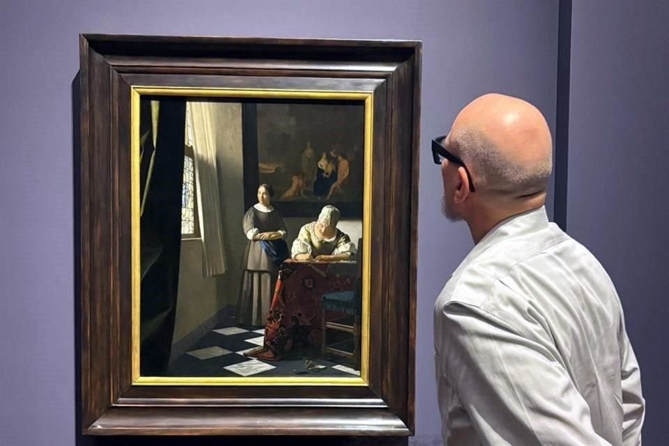 'La mujer escribiendo una carta con su criada', uno de los tres lienzos que conforman la exposición 'Cartas de amor de Vermeer' en el museo de la Frick Collection.