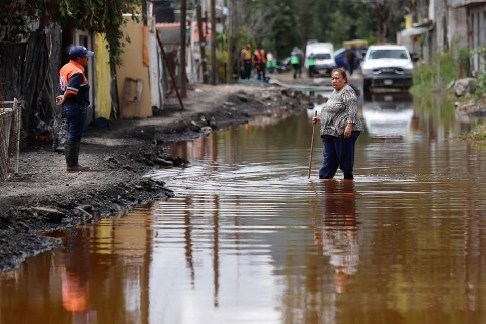 ENTRE AGUA. Vecinos de Atotolco tuvieron que comprar botas y usar palos para guiarse al caminar en la anegación.