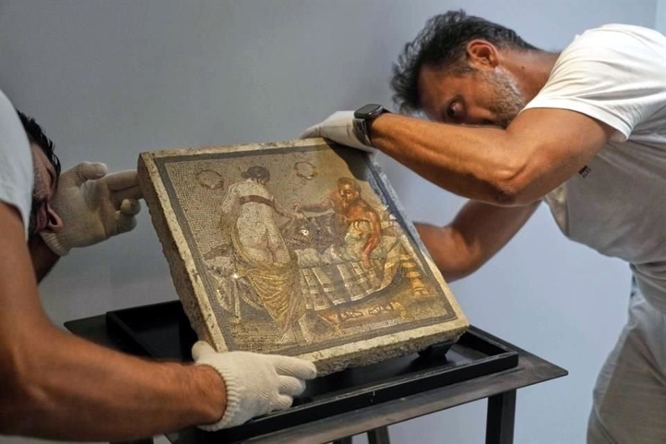Restauradores exhiben el mosaico en travertino que representa a una pareja de amantes, repatriado desde Alemania y entregado a la zona arqueológica de Pompeya.