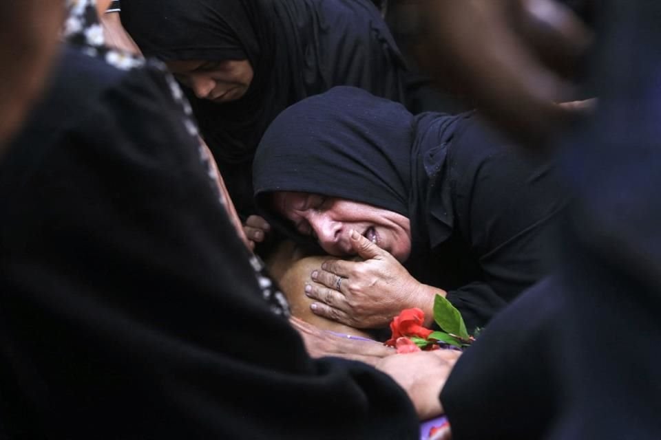 Una mujer palestina llora junto al cuerpo de un hombre, asesinado en un punto de distribución de alimentos en la zona de Al-Tina.