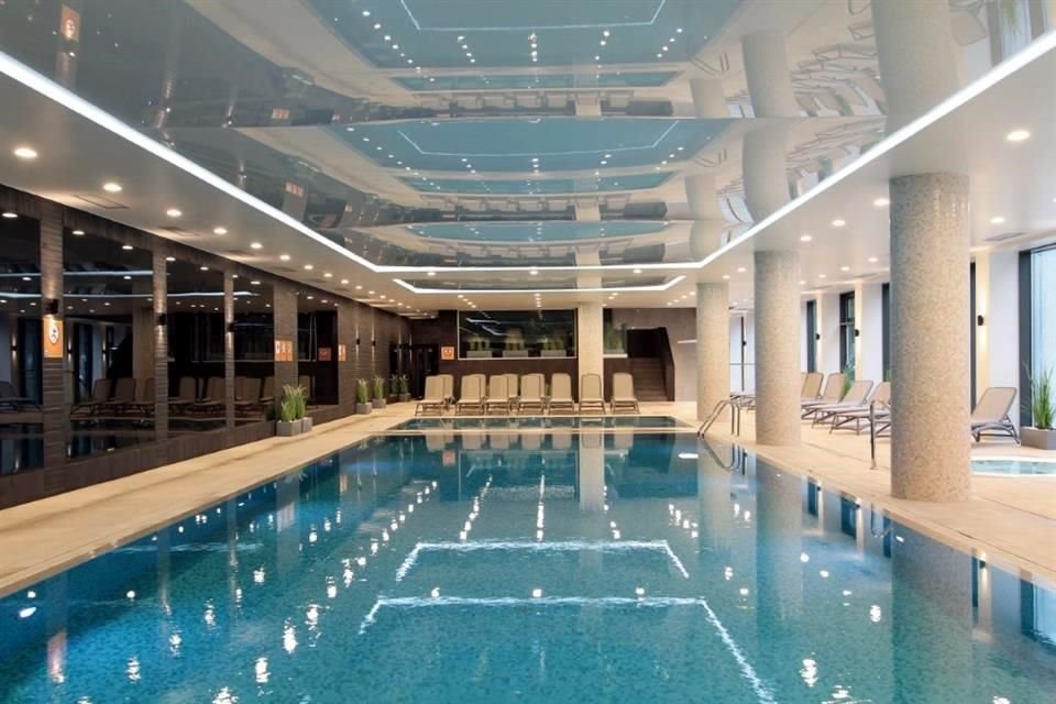 Los cálidos tonos de la colección de gres porcelánico Amazzonia de Casalgrande Padana revisten el piso de la piscina y algunos muros.