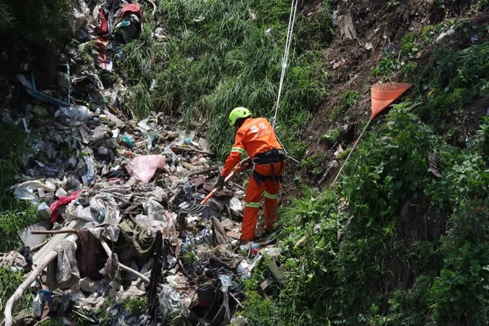 Trabajadores de la Alcaldía usan arneses para retirar la basura acumulada.