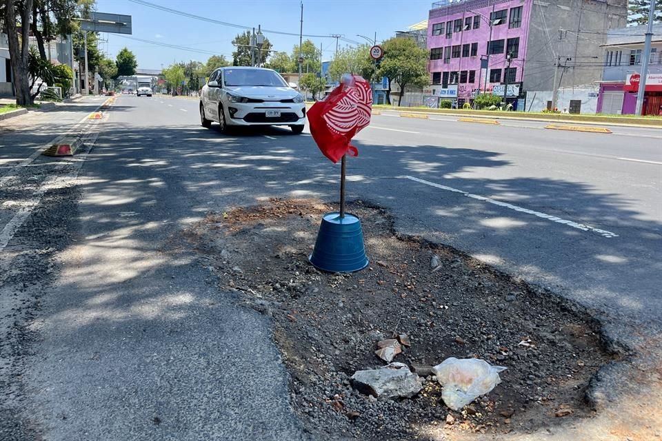 Para muestra, un bache sobre Eje 3 Eduardo Molina. Tanto tiempo lleva abierto, que ya tiene banderola de advertencia.  