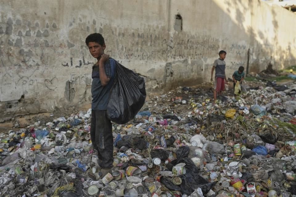 Niños buscan entre la basura en la Ciudad de Gaza, el 27 de agosto del 2025.