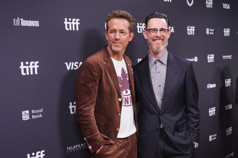 Reynolds, orgulloso canadiense y súper fan del hockey nacional, le dijo a sus fans que se sentía feliz de estar en su País. Aquí, posa junto al director del documental, Colin Hanks.