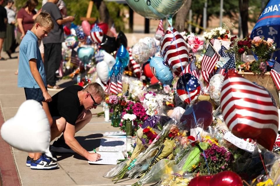 Personas visitan un memorial afuera de las oficinas de Turning Point USA, en Phoenix, el 14 de septiembre.