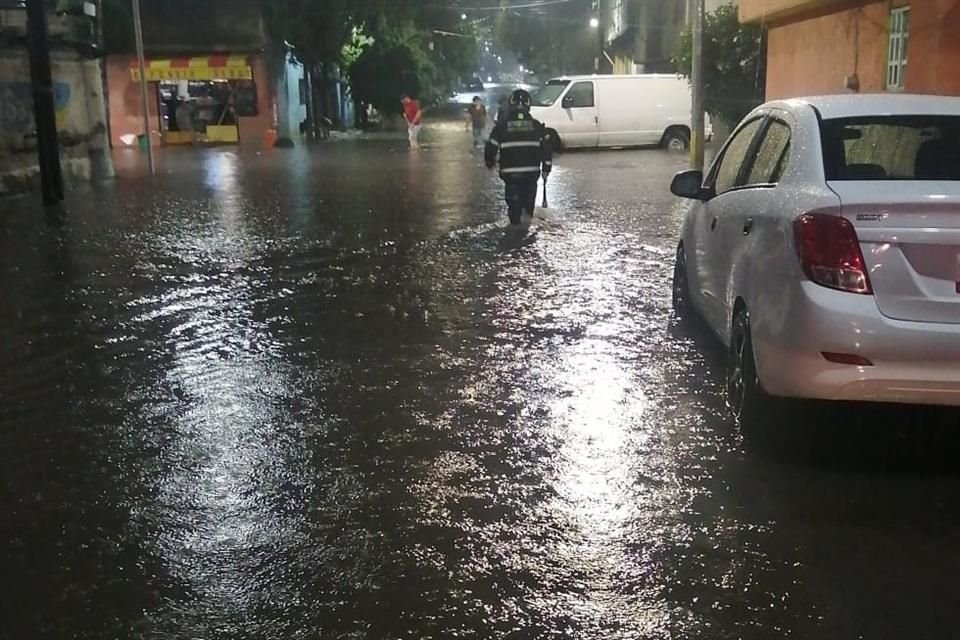 Bomberos laboran en el desalojo de agua pluvial en Calle María Dolores Obregón, Colonia San Sebastián, en Tláhuac.