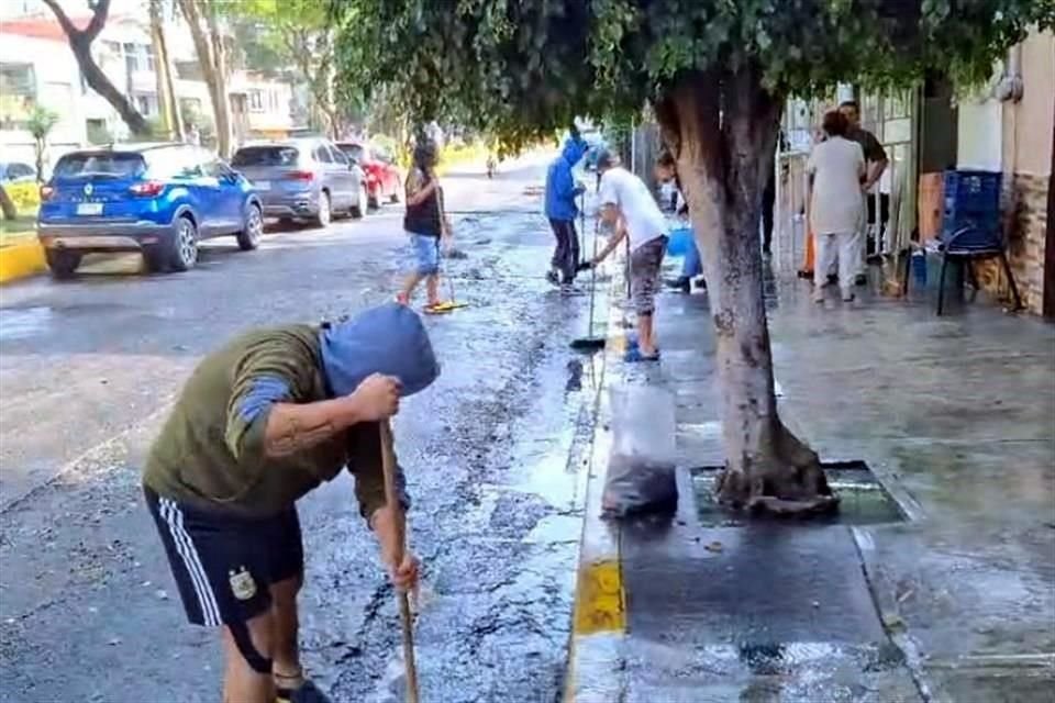 Habitantes limpian calles y banquetes tras la tormenta de ayer.