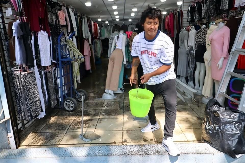 Comerciantes del centro histórico, se dan a la tarea de limpiar sus locales y sacar el agua de lluvia.