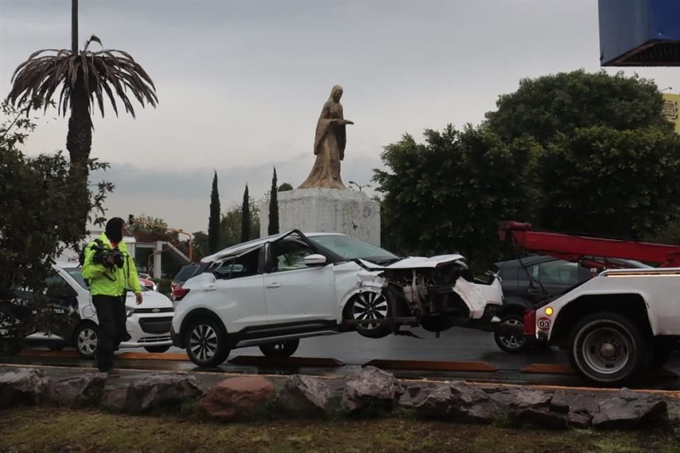 Parte de la estructura afectó una camioneta Nissan blanca y la caja de un camión de carga.