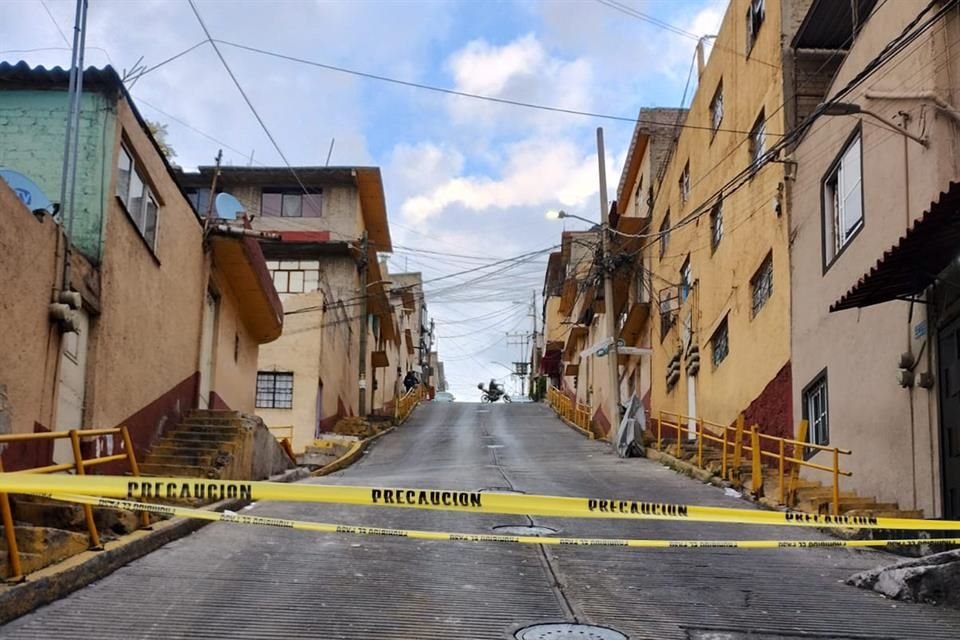 CUESTA ABAJO. Con una inclinación de 45 grados, la calle luce cerrada al paso vehicular, en tanto autoridades trabajan en el retiro de escombro y limpieza del asfalto.