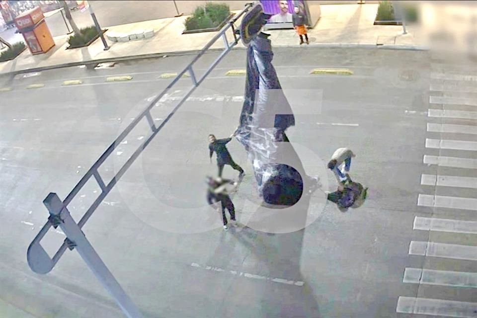 Para liberar su paracaídas, el hombre tira con fuerza del mismo a tal punto de sacudir el poste del semáforo.