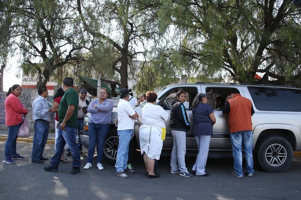 A unas calles de la seccin electoral 2451, tras votar, personas se formaban afuera de una camioneta gris para mostrar su credencial de elector y compararla en una lista.