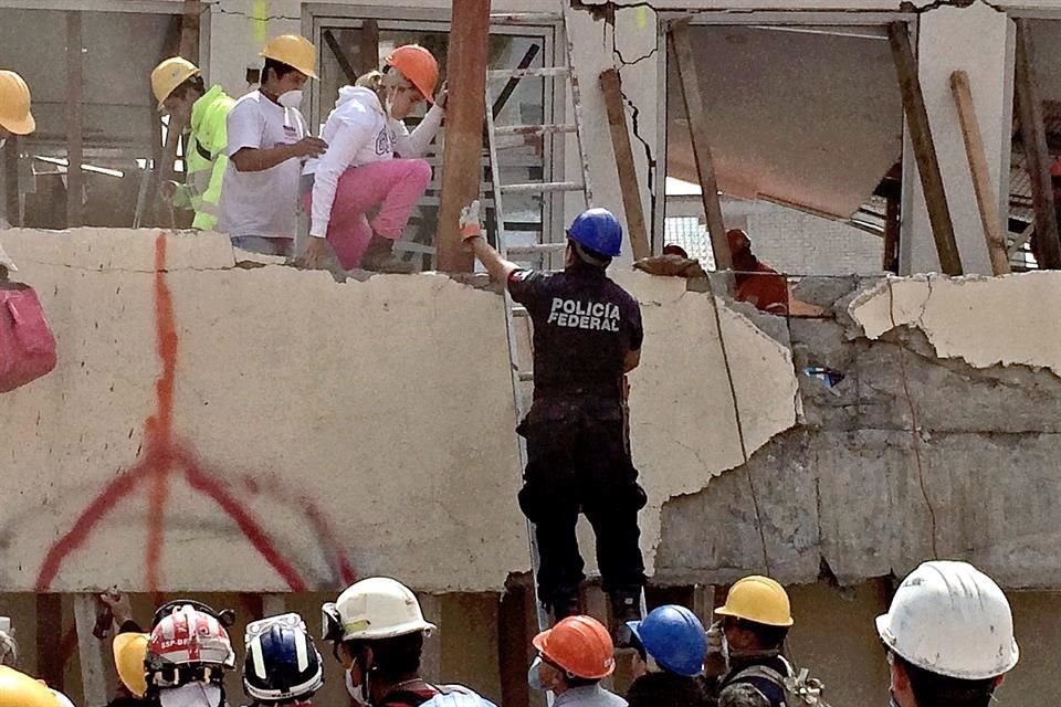 Mónica Villegas (pantalón rosa) ayudó a la Marina a hacer un croquis de la estructura colapsada.