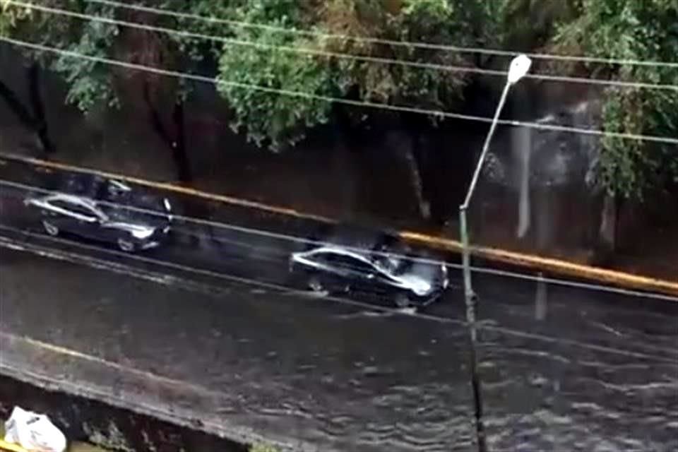 Entre Avenida Las Torres y Calzada Arenal, el agua cubre las llantas de los automóviles.